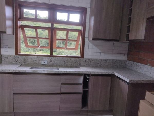 Cozinha em L com bancada em pedra e armários amadeirados