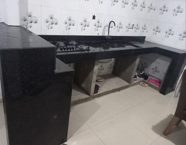 Bancada de cozinha em pedra escura com cooktop