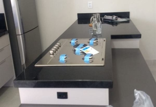 Bancada de cozinha em pedra escura com cooktop