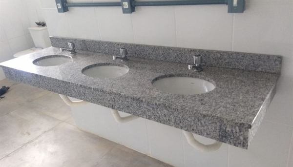 Bancada em pedra cinza com três cubas