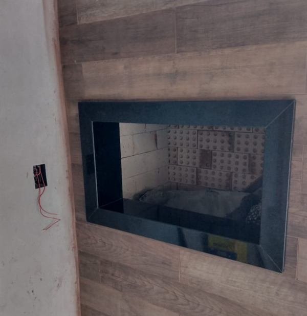 Moldura em pedra escura em churrasqueira com parede amadeirada