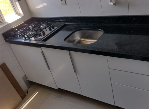 Bancada em pedra escura com cooktop e cuba